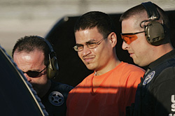 Jose Padilla, center, is escorted to a waiting police vechicle by federal marshals near downtown Miami in this Jan. 5, 2006, file photo. (AP Photo/J. Pat Carter) 