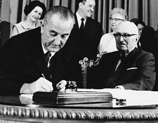 President Lyndon B. Johnson signing the Medicare Bill in Independence, Mo., on July 30, 1965, with honorary guest former President Harry S. Truman.