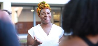 A student greets classmates at the student organization fair