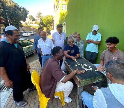 Students and men playing dominoes