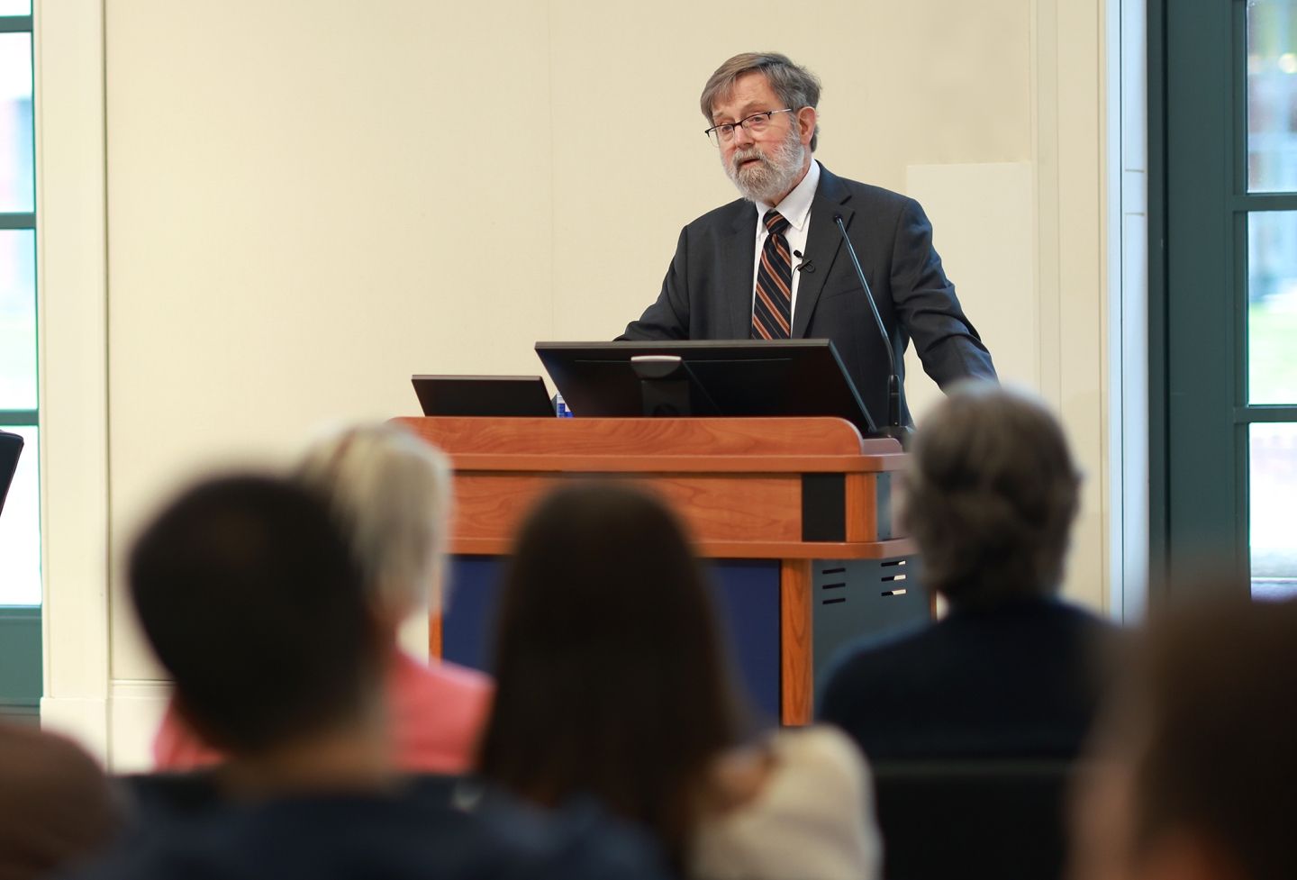 Edwin Kneedler speaks at the podium in Caplin Pavilion