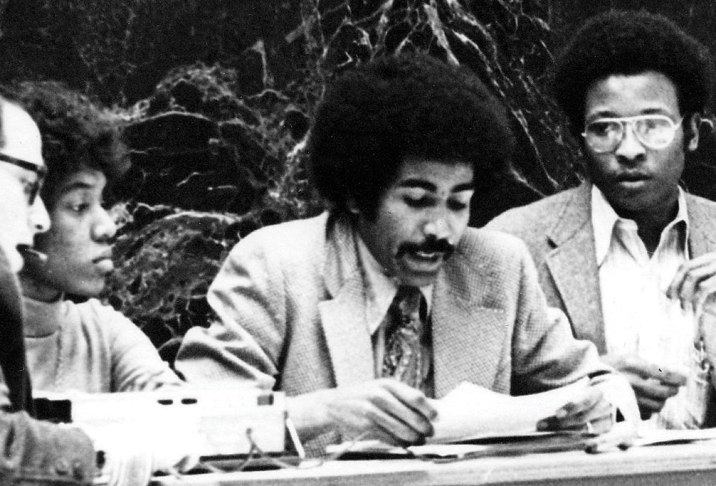 Bobby Vassar ’72, middle, speaks at a 1972 BALSA press conference on recruiting Black faculty. To the left and right of Vassar are Margaret Poles Spencer ’72 and Leonard McCants ’72, flanked by members of the press. 