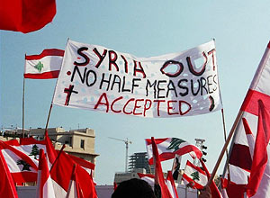 Protest sign showing: Syria out - No Half Measures Accepted