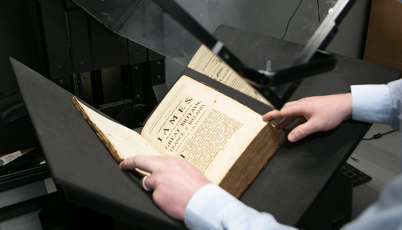 A book once owned by a Scottish lord, now owned by UVA as part of the collection it's compiling, is prepared for scanning.