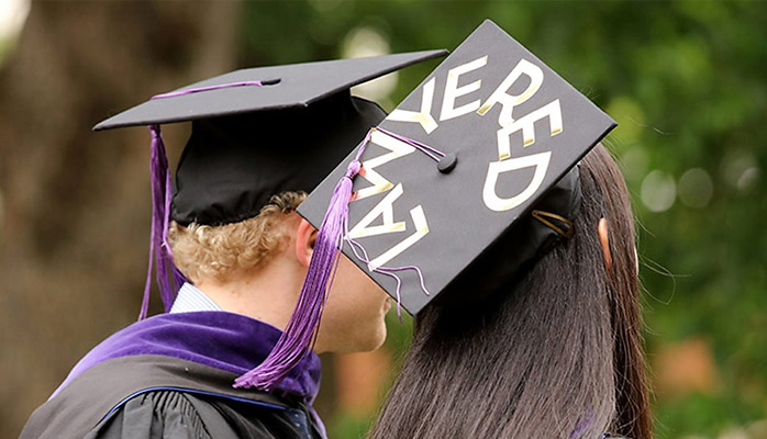 Student with "Lawyered" written on mortarboard